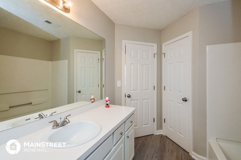 a bathroom with a sink and a mirror and two doors