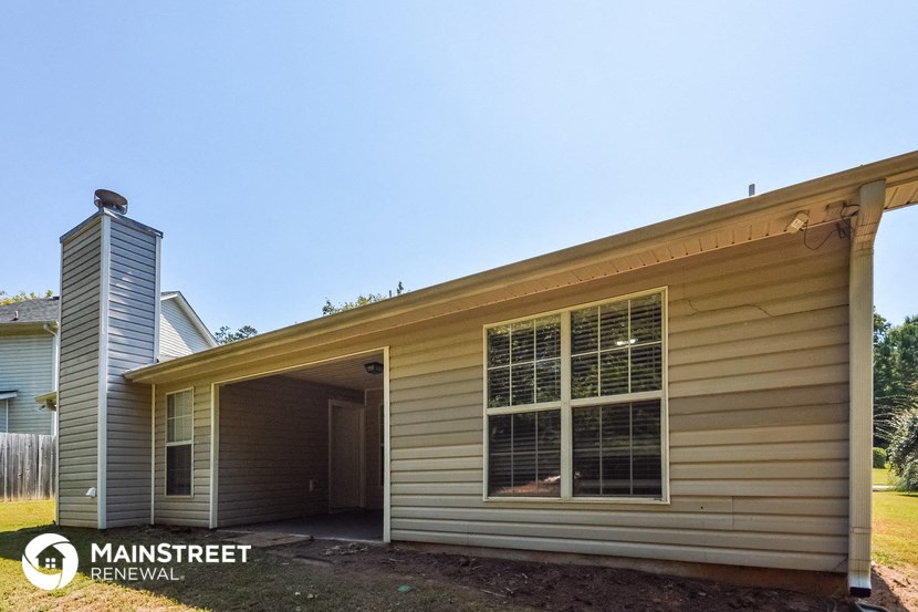 the front of a tan house with a garage door