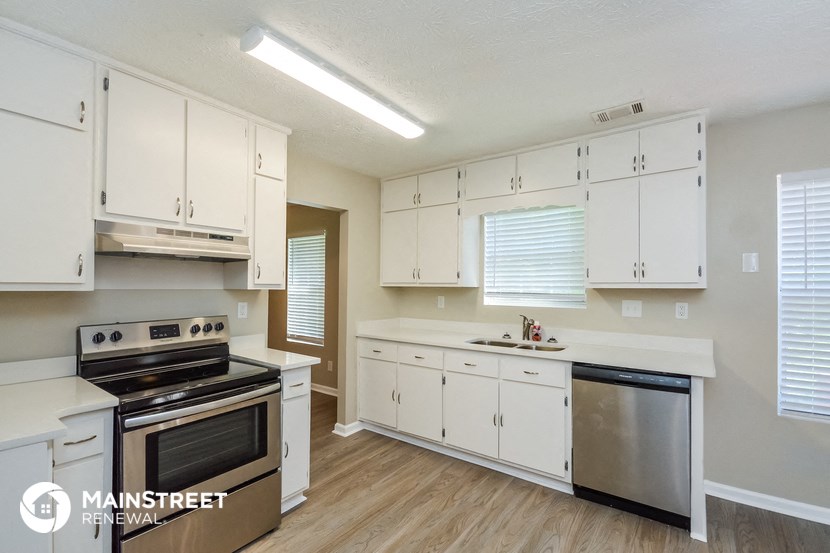 a kitchen with white cabinets and stainless steel appliances