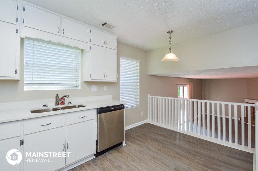 a kitchen with white cabinets and a white counter top and a sink