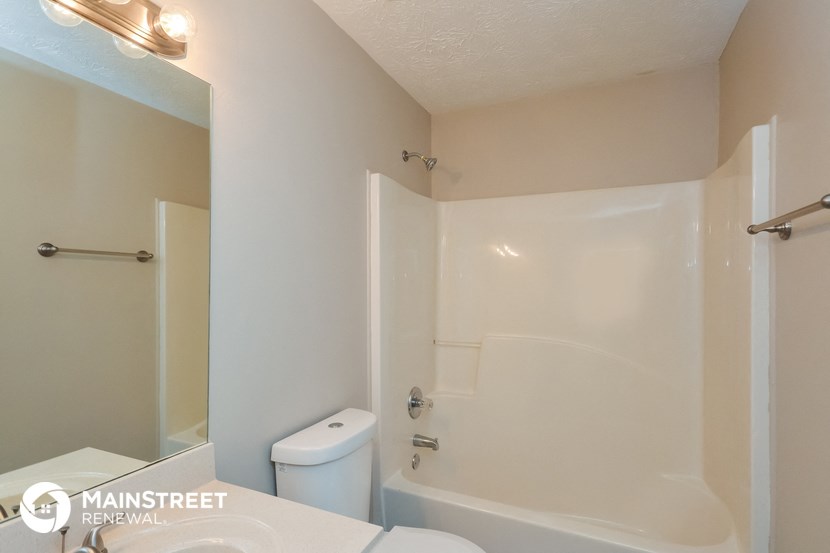 a bathroom with a shower and a sink and a toilet