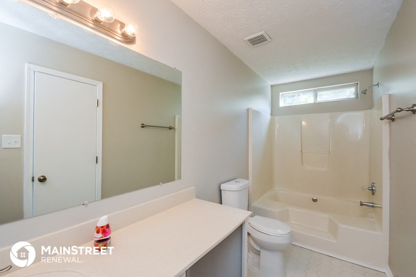 a bathroom with a shower toilet and sink and a mirror