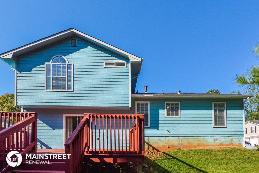 a blue house with a porch and a red deck