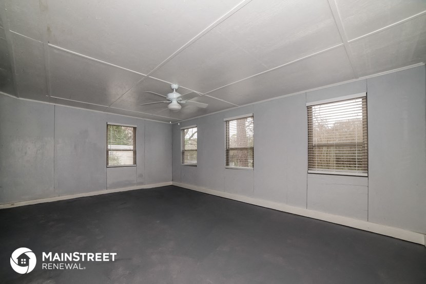 the interior of an empty room with a ceiling fan