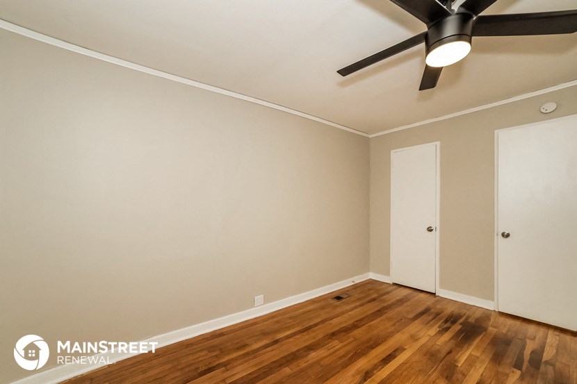 the bedroom with wood flooring and a ceiling fan