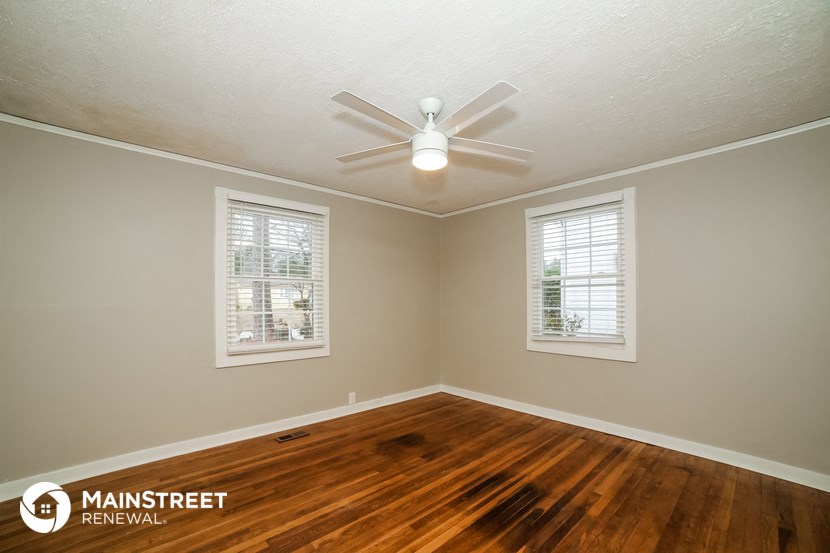 the interior of a room with wood floors and a ceiling fan