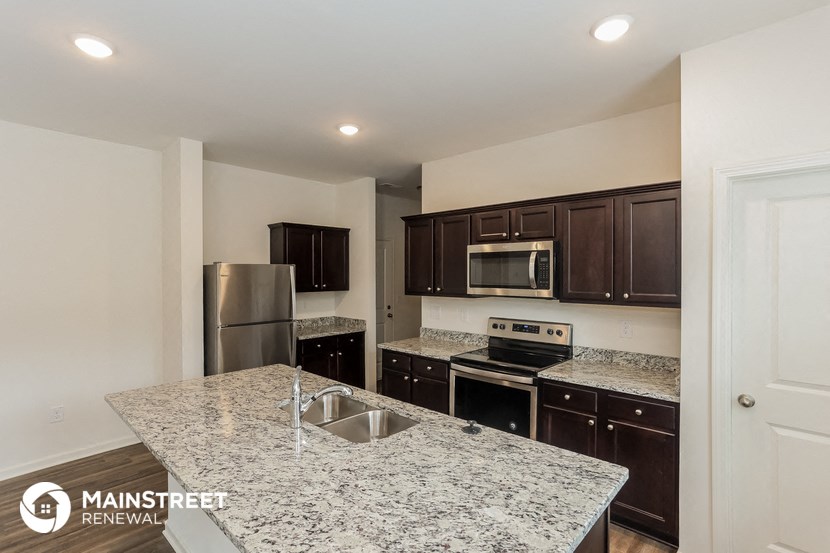 the kitchen has granite counter tops and stainless steel appliances