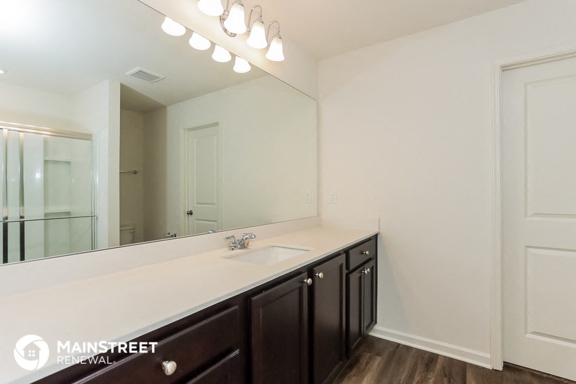 the master bathroom has a large mirror and a large sink