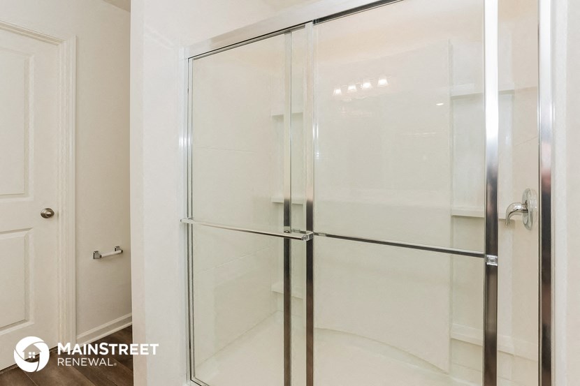 a bathroom with a shower with a glass door