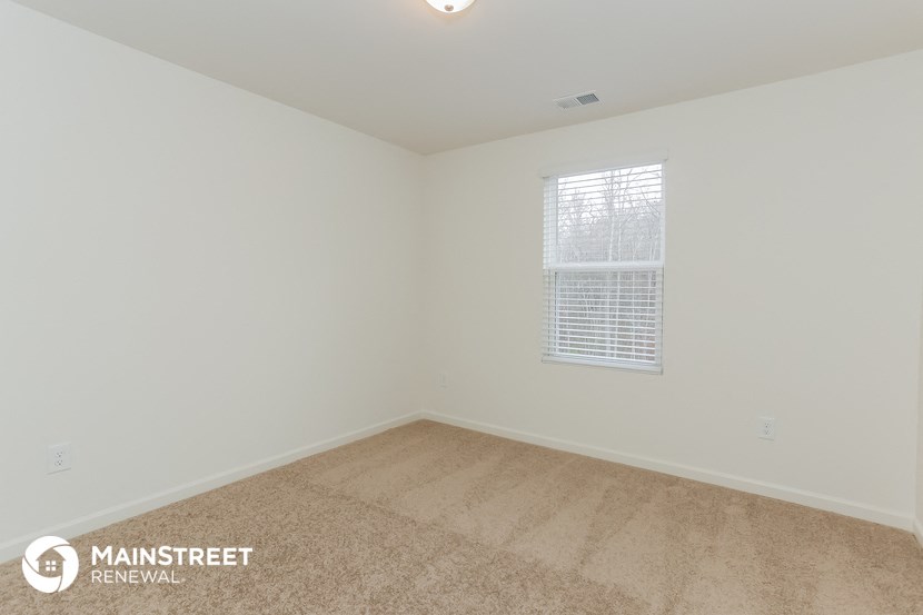 the upstairs bedroom with carpet and window