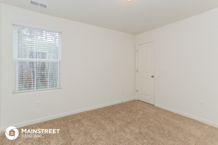 the upstairs bedroom with carpet and a door to the bathroom