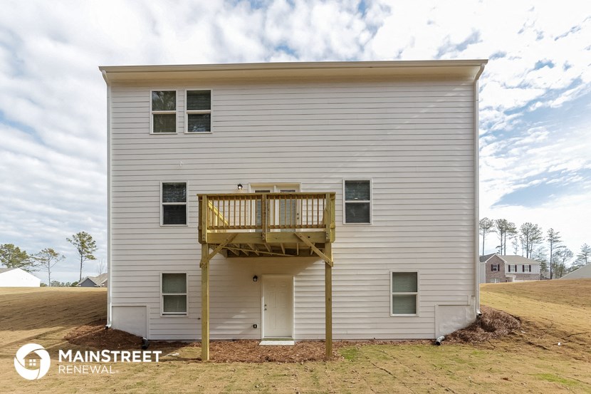 the view of the back of the house with a deck