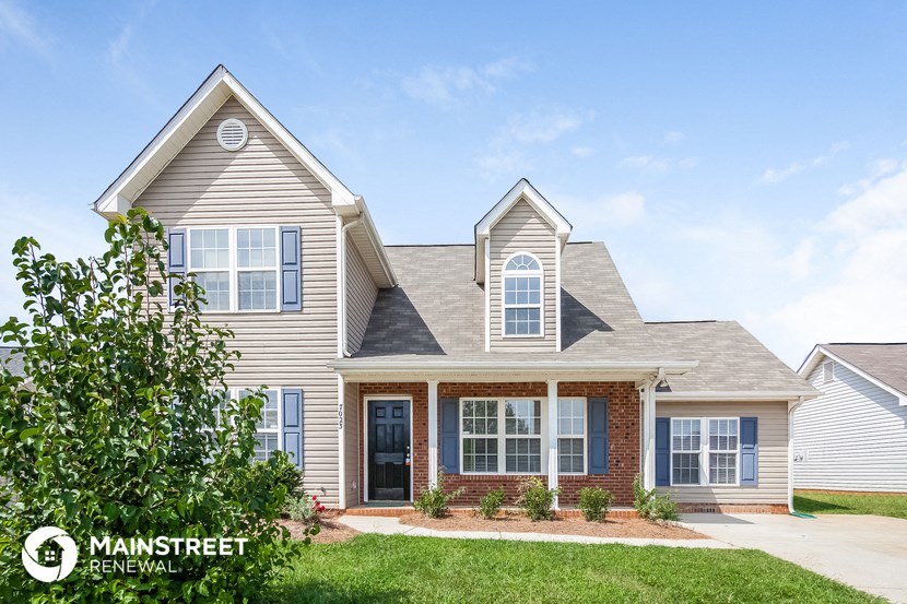 a house with two peaked roofs and a lawn