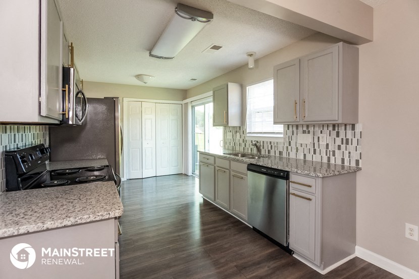 a kitchen with white cabinets and granite counter tops and a stainless steel appliances