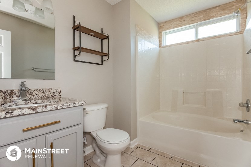 the bathroom has a tub and a toilet and a sink