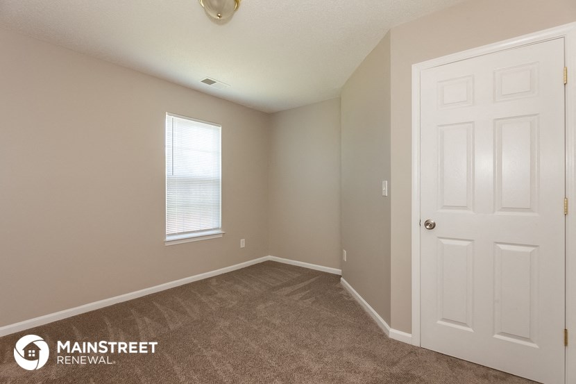 the upstairs bedroom has a carpeted floor and a white door