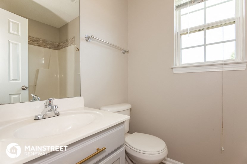 a bathroom with a sink toilet and a mirror