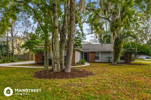 a house with trees in front of it and a yard