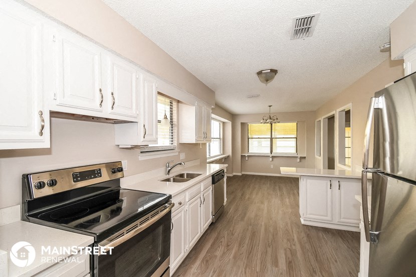 a kitchen with white cabinets and a stove and a refrigerator