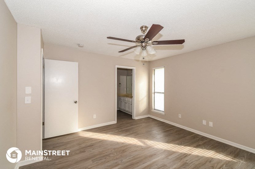 the spacious living room with ceiling fan and closet