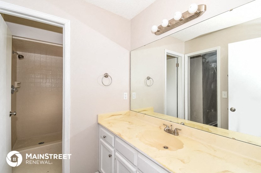 a bathroom with a sink and a mirror and a shower