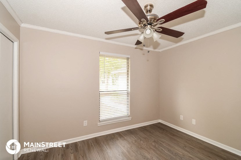 a bedroom with a ceiling fan and a window