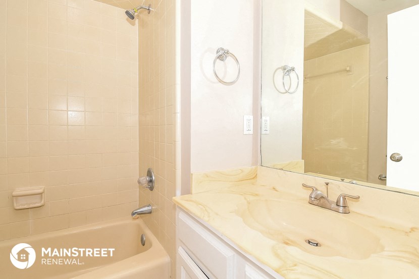 a bathroom with a sink and a tub and a mirror