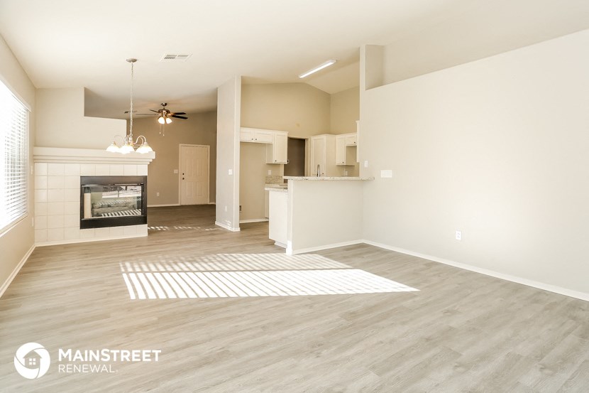 a living room with a fireplace and a kitchen