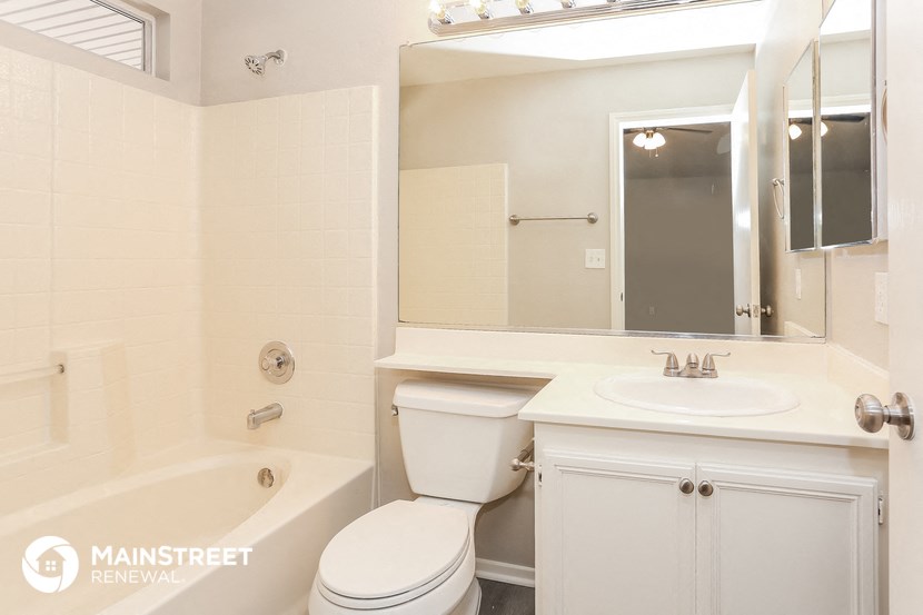 a bathroom with a toilet sink and mirror and a tub