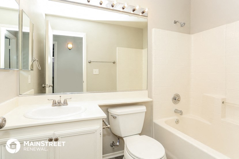 a bathroom with a sink toilet and a mirror and a tub