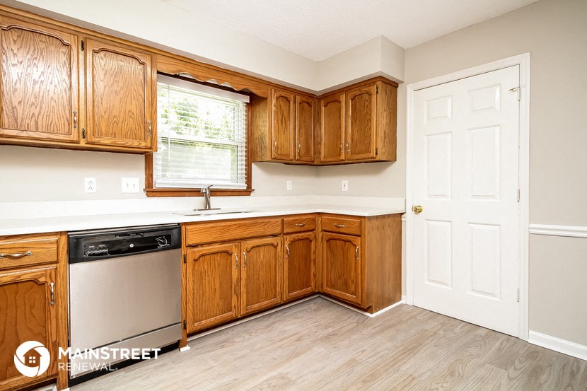 a kitchen with wooden cabinets and a dishwasher and a window
