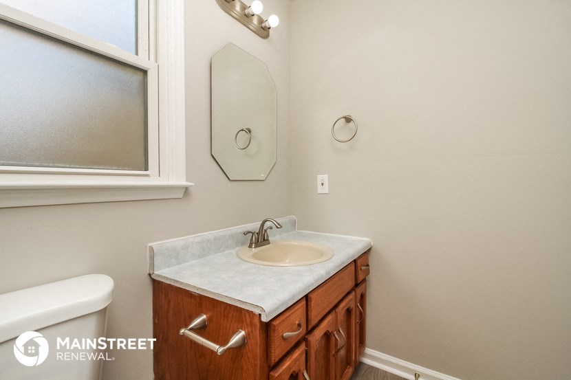 a bathroom with a sink and a mirror and a window