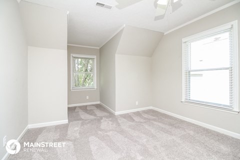 the living room of a new home with carpet and windows