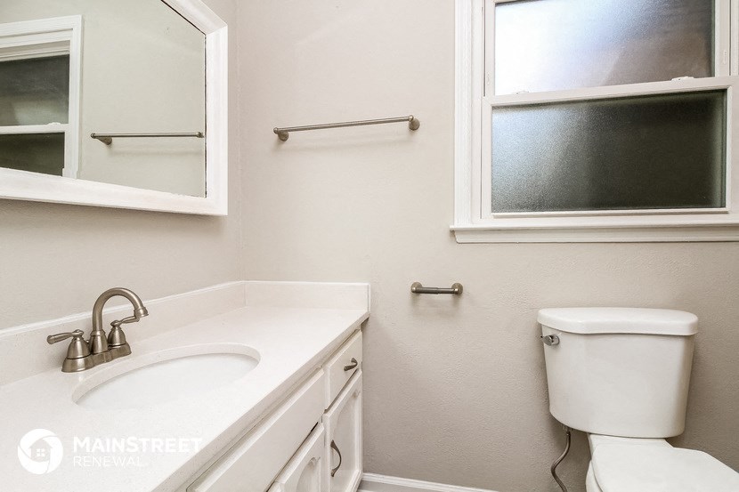 a bathroom with a toilet and a sink and a mirror