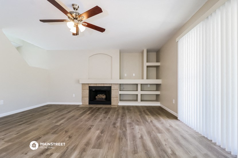 a living room with a fireplace and a ceiling fan