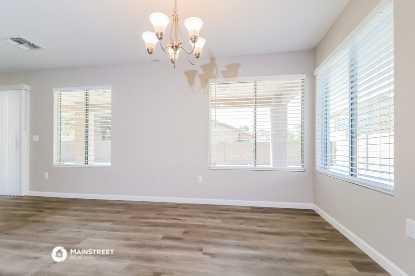the living room of a new home with windows and a chandelier