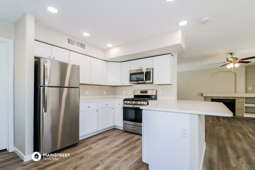 a kitchen with white cabinets and stainless steel appliances