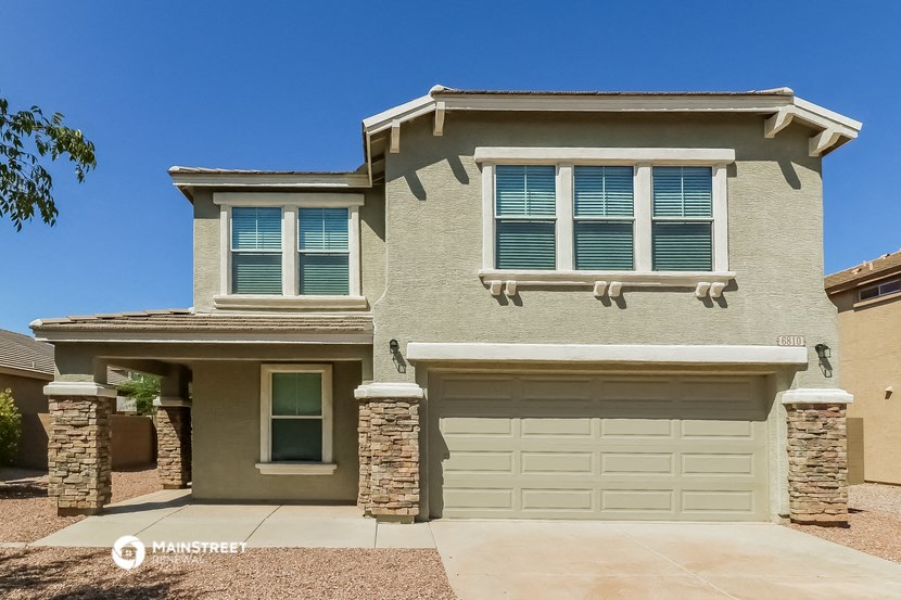 a tan house with a white garage door