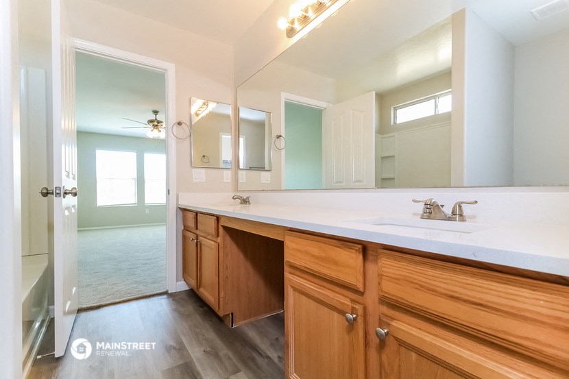 the master bathroom has a large vanity and a large mirror