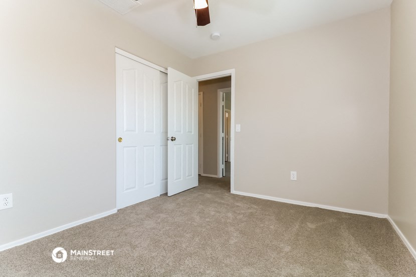 a bedroom with two closets and a door to a hallway