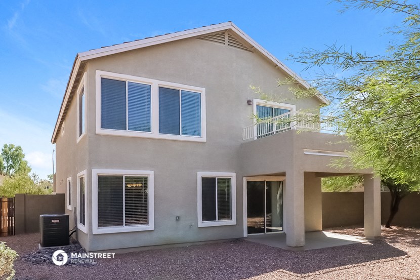 a beige house with a tree in front of it