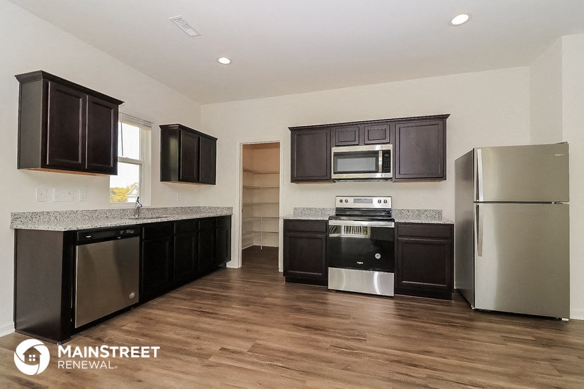 a kitchen with black cabinets and stainless steel appliances