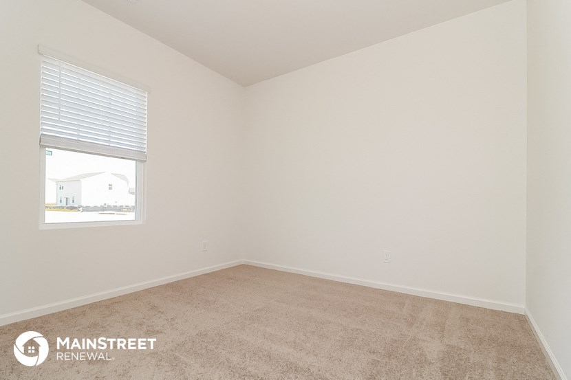the spacious living room with carpeting and a window