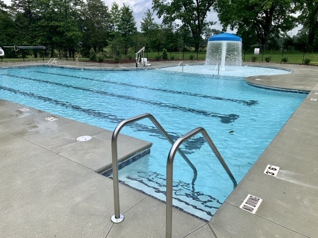 a large swimming pool with a water fountain