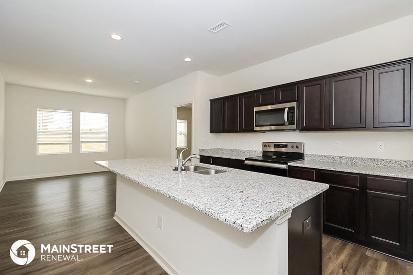 a kitchen with granite counter tops and black cabinets