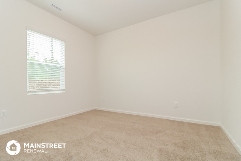 the upstairs bedroom with carpet and window