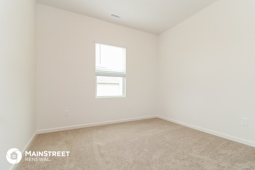 a bedroom with a carpeted floor and a window