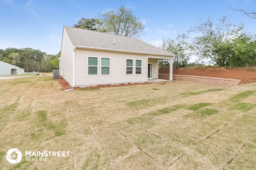 a small white house with a yard in front of it