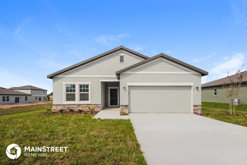 a white house with a garage door and a driveway