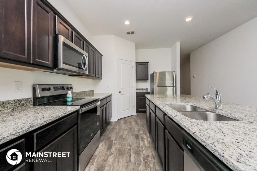 a kitchen with marble counter tops and black cabinets